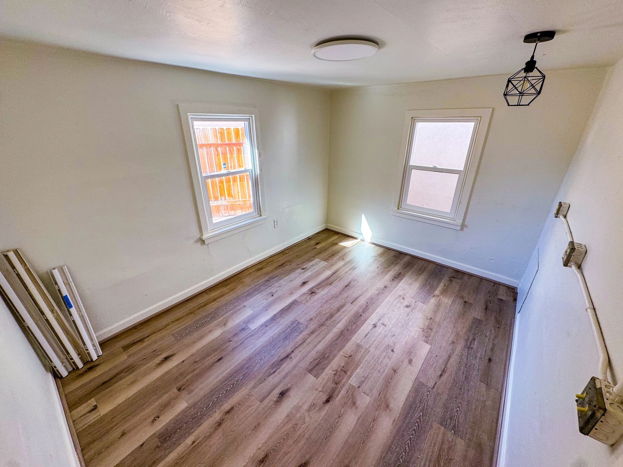 Bedroom with wood-look flooring and natural light for a Hawaii home